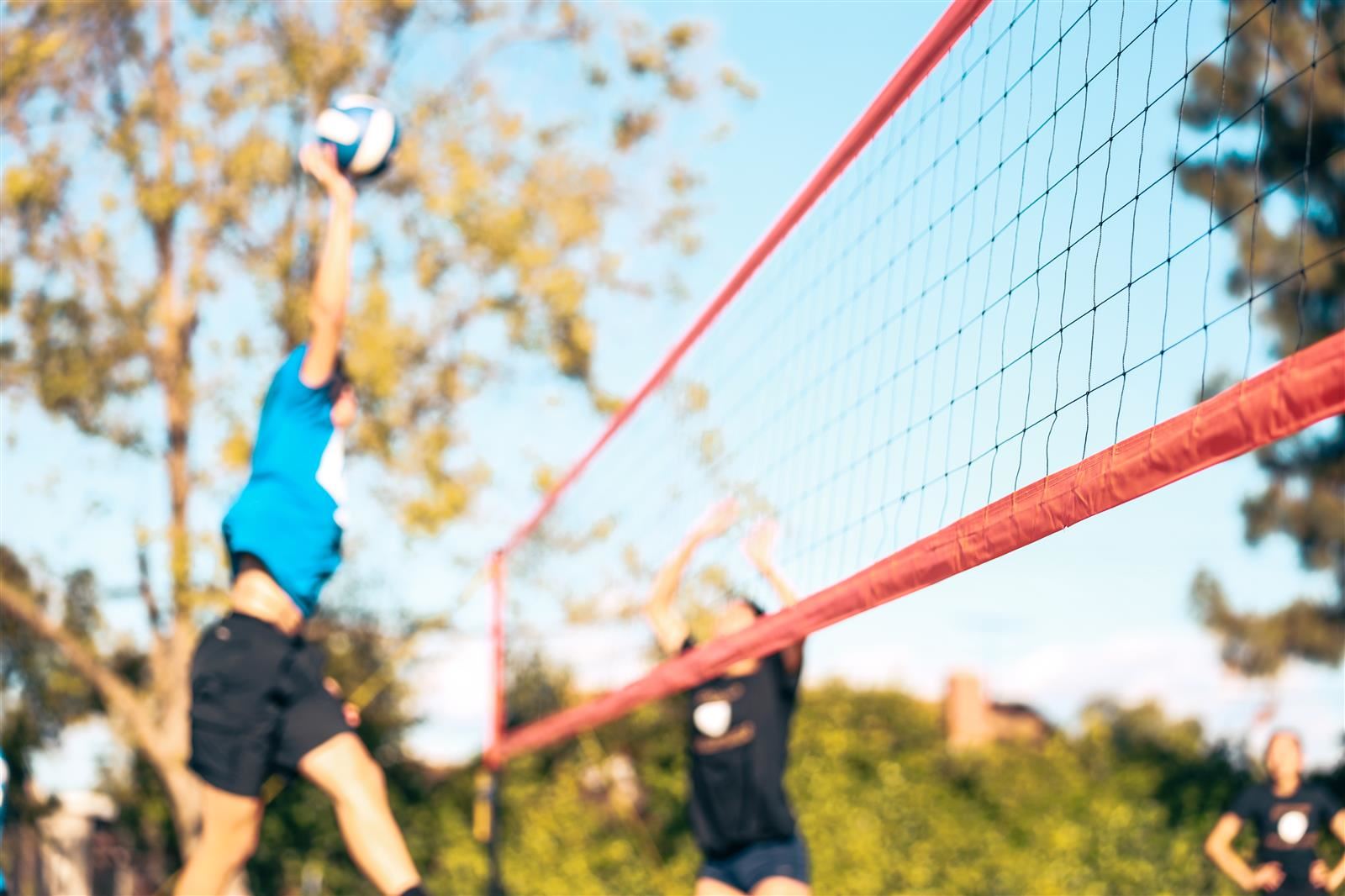  students playing volleyball at the park